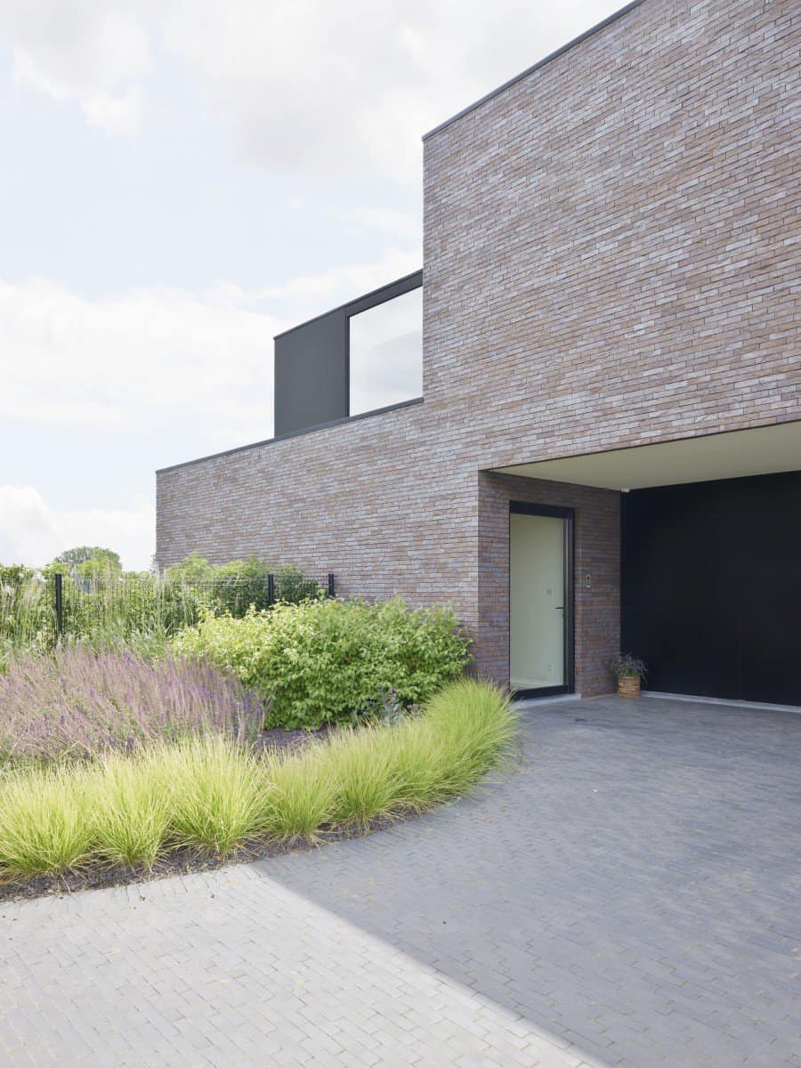 nieuwbouwwoning in Dendermonde met oprit in kleiklinkers gevelsteen en zwarte vlakken in Trespa